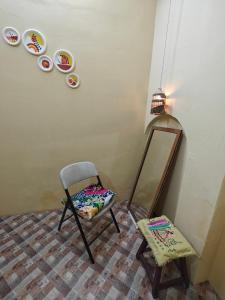 バラナシにあるRudravasa Luxury Stayの椅子、鏡、スツール付きの部屋