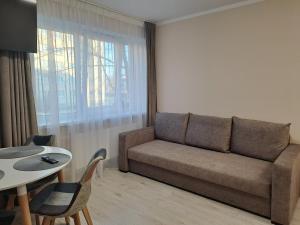 a living room with a couch and a table at Sun 2 in Rēzekne