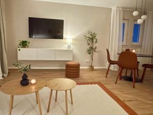 a living room with a tv and a table and chairs at Westflügel Apartment mit Parkplatz und zentraler Lage in Bad Rothenfelde