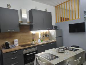 a kitchen with grey cabinets and a table in it at Un nido nel Borgo in Piazza Armerina