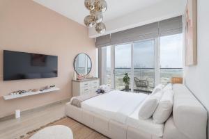Un dormitorio blanco con una cama grande y una ventana grande. en An Exceptional Studio in JVC that Sleeps 2!, en Dubái