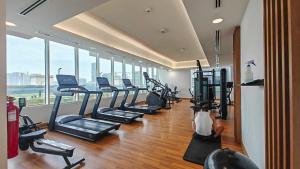 un gimnasio con una fila de cintas de correr y bicicletas estáticas en An Exceptional Studio in JVC that Sleeps 2!, en Dubái