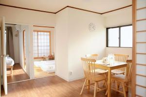 una stanza con tavolo e sedie e una camera da letto di 德川 CU Host CASA ad Osaka