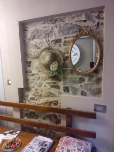 a mirror on a stone wall next to a table at BARDI AL RIOLO la QUERCIA in Bardi