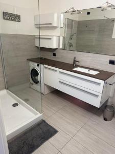 a bathroom with a sink and a washing machine at Casa di Spino in Faggeto Lario  +30 photos