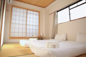 due letti in una stanza con ampie finestre di 德川 CU Host CASA ad Osaka