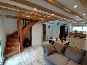 ein Wohnzimmer mit einer Couch und einer Treppe in der Unterkunft Le Pommier Gite neuf avec parking privé clos in Jullouville-les-Pins
