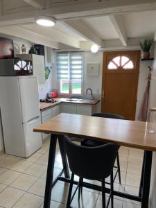 a kitchen with a table and chairs and a refrigerator at Studio meuble in Marssac-sur-Tarn +1 photo