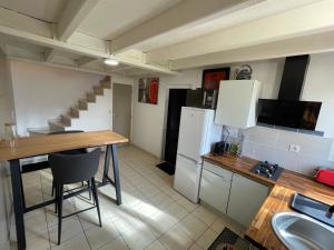 a small kitchen with a table and a refrigerator at Studio meuble in Marssac-sur-Tarn