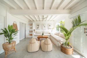 a living room with a couch and two potted plants at Beach Tonic Lembongan in Nusa Lembongan +43 photos