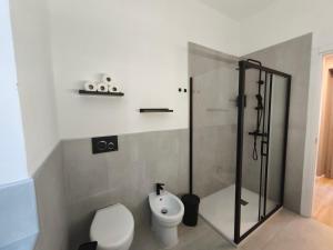 a bathroom with a toilet and a glass shower at La Terrazza in Centro in Treviglio
