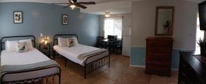 a bedroom with two beds and a dresser and a mirror at El Rancho Motel in Bishop
