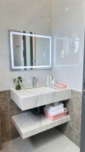 a white bathroom with a sink and a mirror at Khách Sạn 1-CSLTDL-89- PHT in Xuan An