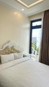 a bedroom with a large white bed with a window at Khách Sạn 1-CSLTDL-89- PHT in Xuan An