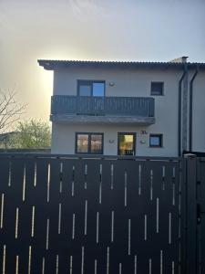 a white house with a fence in front of it at Benchea's House in Alba Iulia +1 photo