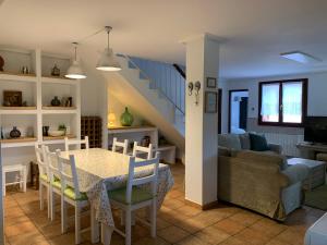 eine Küche und ein Wohnzimmer mit einem Tisch und einer Couch in der Unterkunft La Cabaña de Meruelo in San Miguel de Meruelo