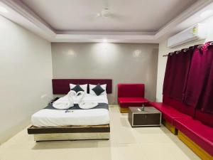 奥兰加巴德Hotel Rajlaxmi Executive的一间卧室配有一张床和一张红色长凳
