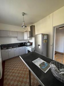 une cuisine avec une table et un réfrigérateur en acier inoxydable dans l'établissement Maison de village 4 chambres, à Neuvy-sur-Loire
