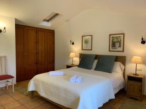 ein Schlafzimmer mit einem Bett mit zwei Handtüchern darauf in der Unterkunft La Cabaña de Meruelo in San Miguel de Meruelo