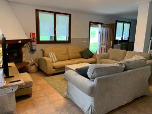 ein Wohnzimmer mit Couch und Kamin in der Unterkunft La Cabaña de Meruelo in San Miguel de Meruelo