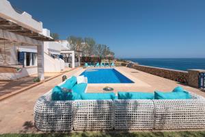 a large wicker couch sitting next to a swimming pool at Domus Alba A in Portocolom