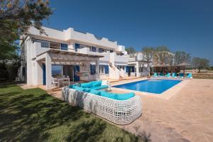 a villa with a swimming pool and blue chairs at Domus Alba A in Portocolom
