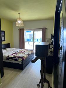 a bedroom with a bed and a desk with a desk at Mikpritja Pogradec, Tushemish 4 in Tushemisht