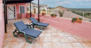 a patio with two chairs and a table on a balcony at Sardinianworld - Josto Panoramic House in S'archittu Cuglieri