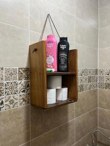a wooden shelf with toiletries on a wall in a bathroom at Banana Surf Lodge in Tamraght Ouzdar