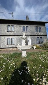 a stone fountain in the grass in front of a building at Zum Alten Pfarrhaus in Damscheid