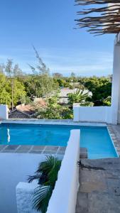 a blue swimming pool with a view of the ocean at Madenge house casa zucchero in Watamu