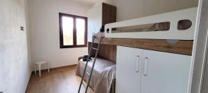 a small bedroom with a bunk bed and a window at Casa Nue - Appartamento Deluxe in Posada +2 photos