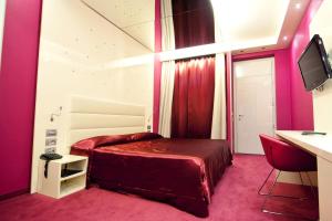 una camera con letto, scrivania e monitor di Albergo Dei Laghi a Turate