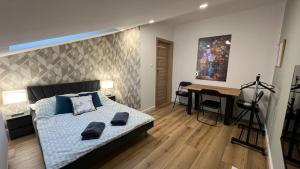 a bedroom with a bed and a desk and a painting at NEW Apartament BLACK Warszawa Parking FREE in Wola Mrokowska