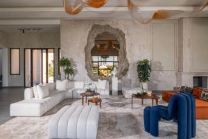 a living room with white furniture and a stone wall at Yin Hotel & Spa in Marrakesh