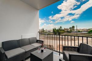 a balcony with two chairs and a table with wine glasses at Modern 2BR Apartment Near Ayia Napa - Anastasia 104 in Xylophaghou