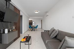 a living room with a couch and a tv at Modern 2BR Apartment Near Ayia Napa - Anastasia 104 in Xylophaghou