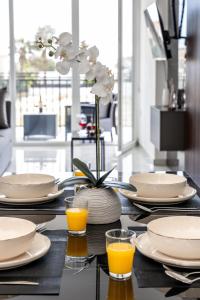 a table with plates and glasses of orange juice at Modern 2BR Apartment Near Ayia Napa - Anastasia 104 in Xylophaghou