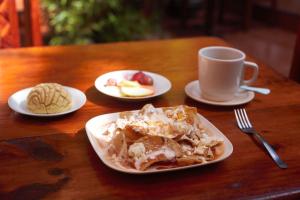 a table with plates of food and a cup of coffee at Capital O Hospedaje Los Angeles San Cristobal De Las Casas in San Cristóbal de Las Casas