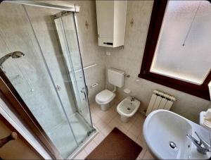 a bathroom with a shower and a toilet and a sink at VILLA CAMPAGNA in Isola Albarella