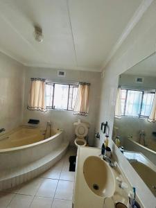 a bathroom with a tub and a toilet and a sink at 692 Annet Drive in Durban