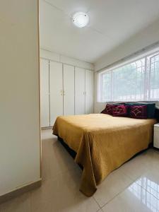 a bedroom with a bed and a large window at 692 Annet Drive in Durban