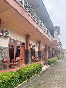 a building with chairs and a balcony on a street at Dewi Ratih Hotel Batang in Batang