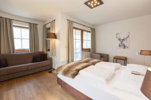 ein Schlafzimmer mit großem Bett und Couch in der Unterkunft Der Unterwirt Guesthouse and Restaurant in Klausen + 37 Fotos