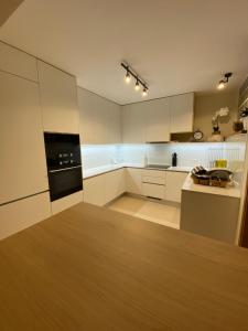 a kitchen with white cabinets and a black oven at Refúgio da praia in Tocha