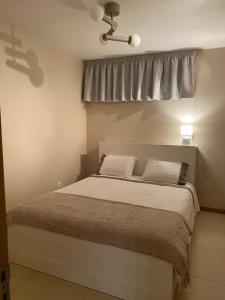 a bedroom with a large bed with a window at Refúgio da praia in Tocha