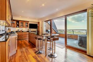a kitchen with a table and a large window at Penthouse Golf View Apartments in Lossiemouth