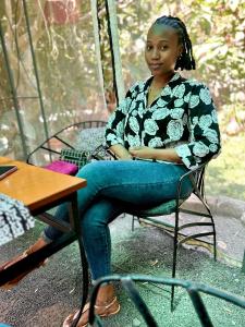 a woman sitting in a chair with her arms crossed at Valley Side Villa in Nkunjila