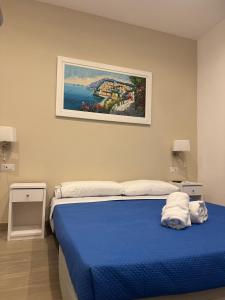 a bedroom with a blue bed with a painting on the wall at Sorrento Bay Apartment in Sorrento