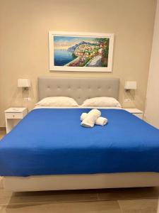 a bedroom with a blue bed with two pillows on it at Sorrento Bay Apartment in Sorrento